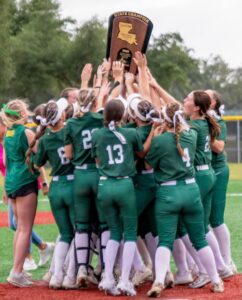 Calvary Softball team huddles around 2024 State Championship trophy in celebration