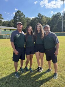 Calvary Softball Coach with assistant coaches pose on the Calvary Softball field